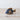A speckled blue fish ornament made of stone or ceramic, with a textured surface, placed on a wooden surface.