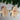 Wooden gingerbread man and woman decorations on a festive background with greenery and candy canes.
